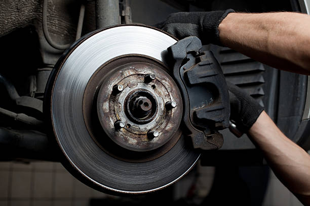 Closeup of car mechanic repairing brake pads Closeup of car mechanic repairing brake pads